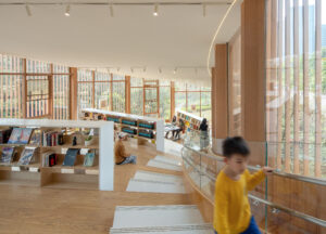 Interior view of the second-floor seating area showing the steel framework, oblique tension enforcement, and operable windows for natural ventilation