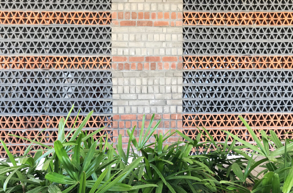 Detail of the terracotta jalli shading devices and alternating layers of red kiln and grey fly ash bricks.