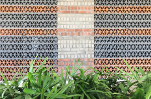 Detail of the terracotta jalli shading devices and alternating layers of red kiln and grey fly ash bricks.