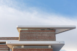 Wide shot of the school building against a blue sky, showcasing the integration of Phase 1 and Phase 2
