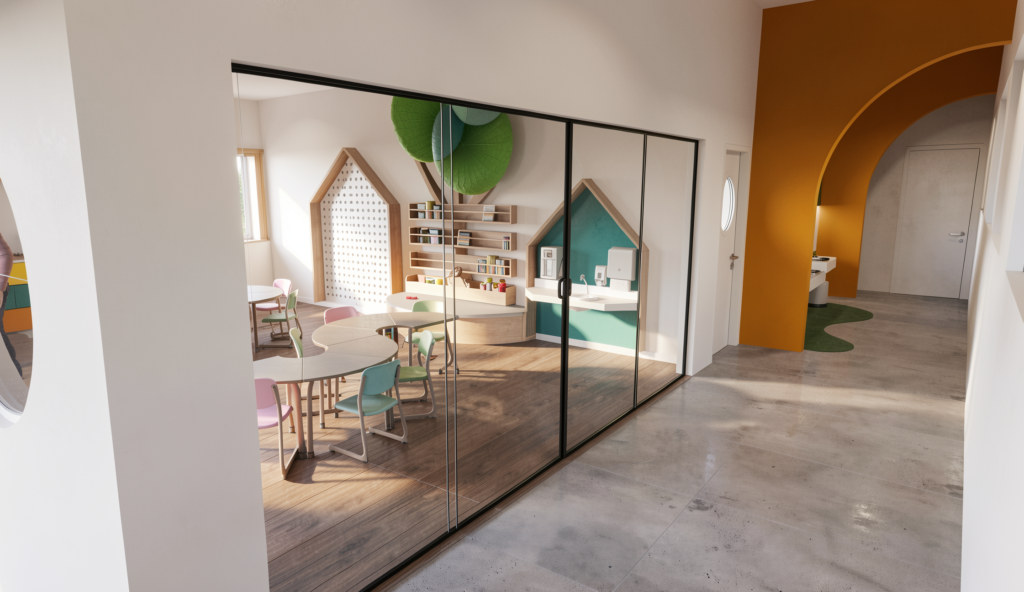 A view through a glass partition into a classroom featuring curved modular desks, pastel chairs, and wall-mounted wooden house-shaped frames that serve as storage nooks and a wash station