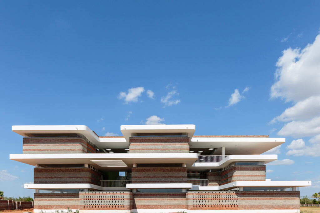 Wide shot of the school building against a blue sky, showcasing the integration of Phase 1 and Phase 2.