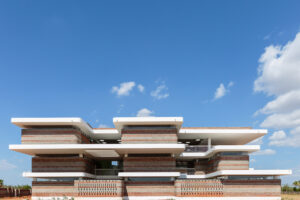 Wide shot of the school building against a blue sky, showcasing the integration of Phase 1 and Phase 2.