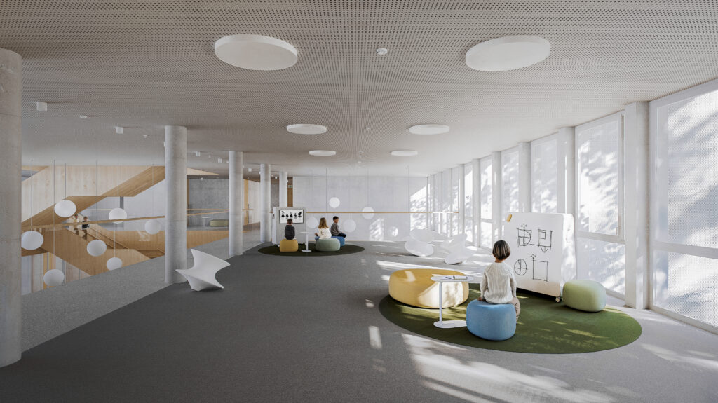 An open common space with circular seating pods and a mobile whiteboard, designed for informal learning and student socialization