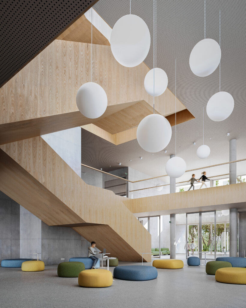 The central core of the school featuring a large wooden staircase, circular hanging lights, and colourful modular seating for students to gather