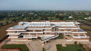 High-angle aerial view of the entire Rane Vidyalaya campus nestled in the rural landscape of Theerampalayam.