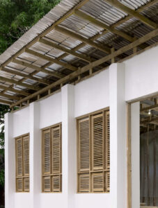 Architectural detail of the library's timber structural system and roof overhang, showing wooden shutters designed to maintain thermal comfort in a hot-humid climate