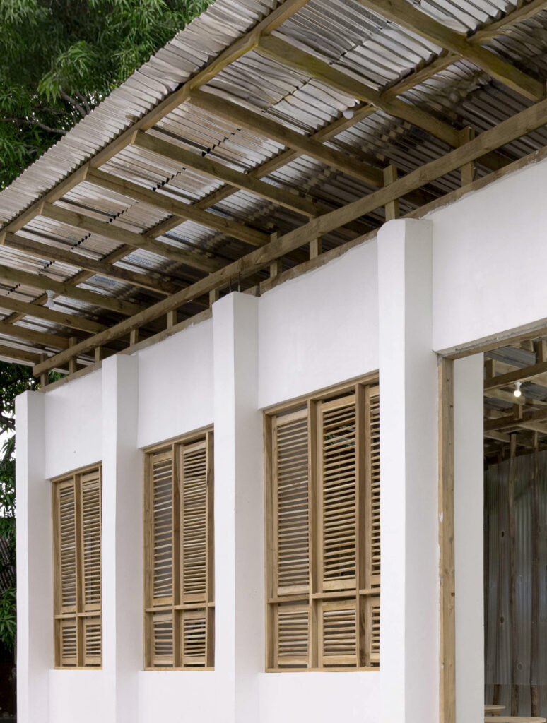 Architectural detail of the library's timber structural system and roof overhang, showing wooden shutters designed to maintain thermal comfort in a hot-humid climate