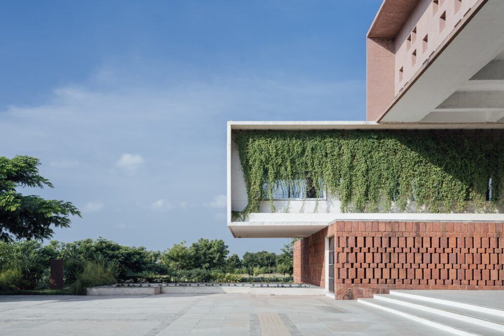 Close-up of a cantilevered wing featuring an ambitious creeper screen that shields the interior from dust and harsh sunlight