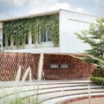 The school building seen from a distance with native grasses and curved pathways in the foreground, blending the architecture with nature
