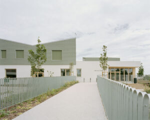 Pathway leading to the entrance of the Children’s Grove facility in Újbuda, showcasing green glazed ceramic tiles and sustainable architectural design