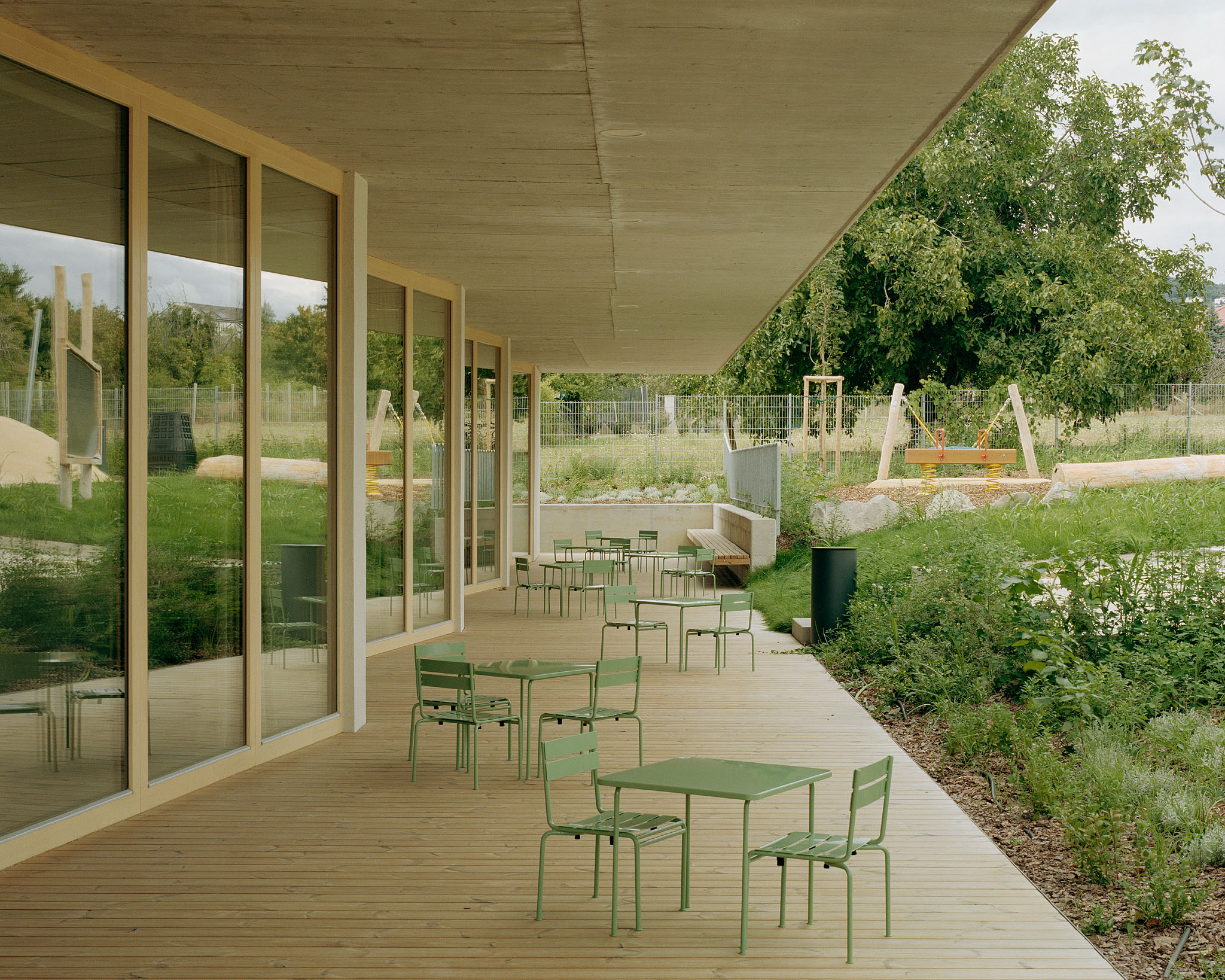 View from the wooden deck at Children’s Grove towards the integrated public playground and green landscape of the Madárhegy hills