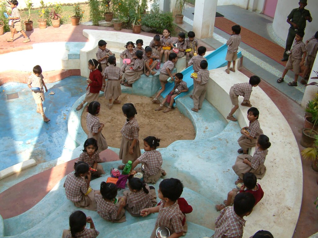 Overhead view of a circular, multi-level play area in the school courtyard featuring colourful china mosaic patterned flooring and slides