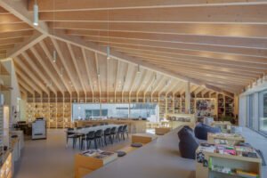 A wide-angle view of the warm wooden library interior, showing bookshelves along the walls and an open central space.