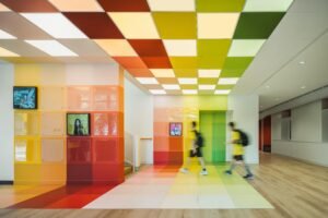 A vibrant music department entrance featuring a grid of multi-colored translucent panels, creating a saturated field of color at the Western Academy of Beijing.