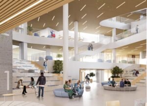 Interior rendering of the primary school’s high-ceilinged central atrium. Strong concrete columns support mezzanine walkways, and the ceiling is lined with warm wood slats. On the left, a large concrete structure features tiered wooden steps where students sit and socialise. Circular grey seating pods are scattered across the floor.