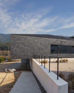 A view of the raised library structure and a concrete path leading toward the lower level.