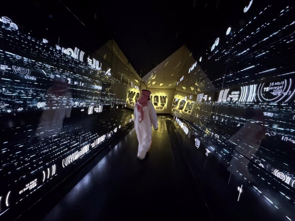 Man in traditional Saudi white thobe walking down a dark infinite mirror corridor filled with glowing data metrics.