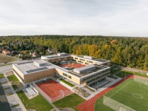 High-altitude aerial photograph displaying the school situated in the countryside between four surrounding Czech villages and forest edge.