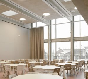 Bright primary classroom with large wood-aluminum window walls overlooking the surrounding countryside and forest.