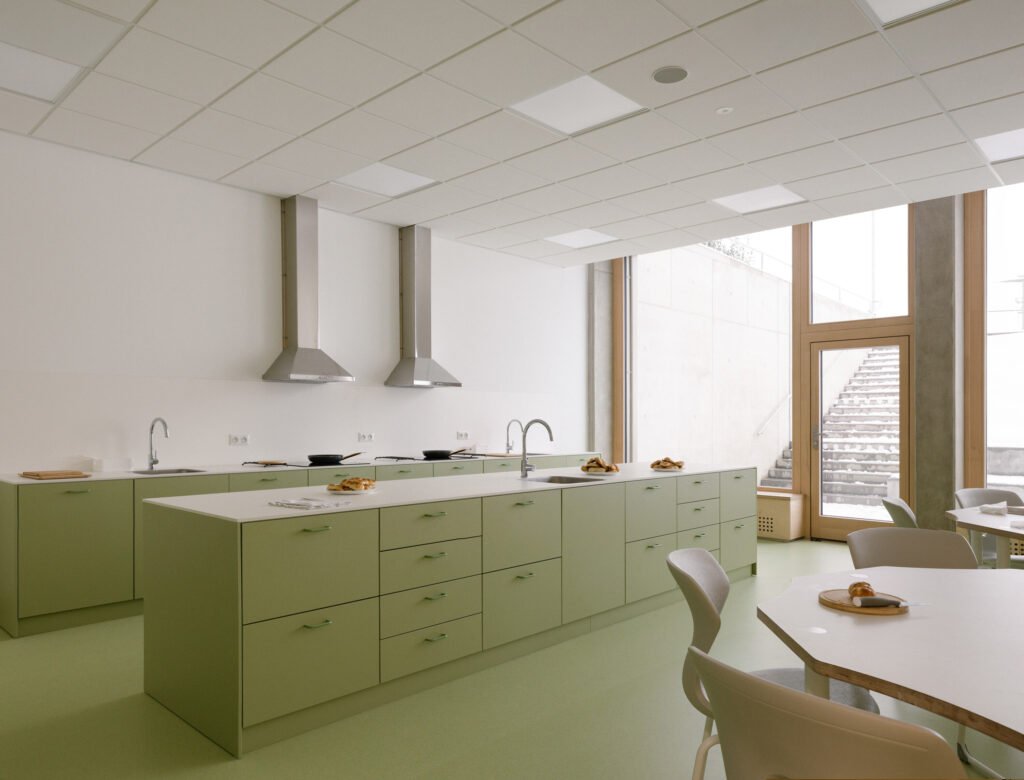 Bright primary classroom with large wood-aluminum window walls overlooking the surrounding countryside and forest.