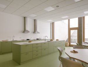 Bright primary classroom with large wood-aluminum window walls overlooking the surrounding countryside and forest.